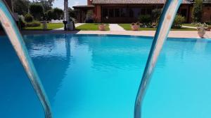 einen Pool mit blauem Wasser vor einem Haus in der Unterkunft La Torre in Taurianova