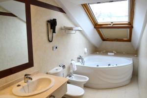a bathroom with a large white tub and a sink at Alda Palacio Valdés in Avilés +48 photos