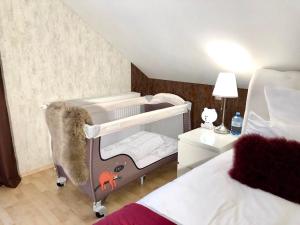 a baby crib in a bedroom with a bed at Baden Airpark Family Apartment in Hügelsheim