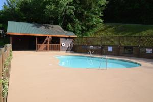 a small swimming pool in a yard with a building at License To Chill in Pigeon Forge