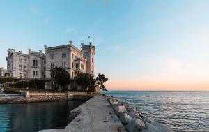 ein Gebäude am Wasser vor dem Meer in der Unterkunft UNICA nel cuore storico di Trieste in Triest