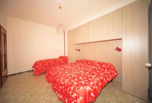 Buona Vacanza في بورجيتو سانتو سبيريتو: غرفة نوم بسريرين مع مرياح احمر