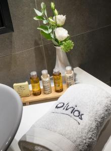 a bathroom with a vase of flowers and a towel at Olvios Design Suite in Thessaloniki