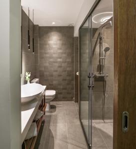 a bathroom with a shower and a sink and a toilet at Olvios Design Suite in Thessaloniki
