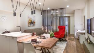 una cucina e un soggiorno con tavolo e sedie rosse di Olvios Design Suite a Salonicco