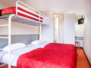 a bedroom with two bunk beds with red blanket at Première Classe Lille Sud Henin Beaumont in Noyelles-Godault