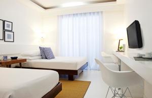 a hotel room with two beds and a tv at Blue Marina Boracay in Boracay