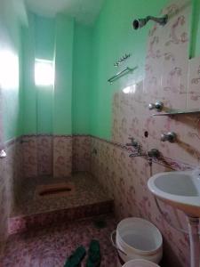 a bathroom with a sink and a toilet and a tub at Madhukunda Homestay in Butwāl