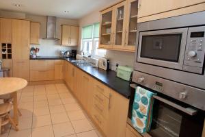 a kitchen with wooden cabinets and a stove top oven at Killinallan Cottage in Port Charlotte +6 photos