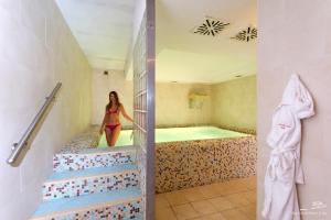 a woman is standing in a tub in a bathroom at Hotel Villa Durrueli Resort & Spa in Ischia