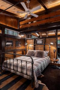 a bedroom with a bed with wooden walls and a ceiling at Vasilikia Mountain Farm & Retreat in Pavliani