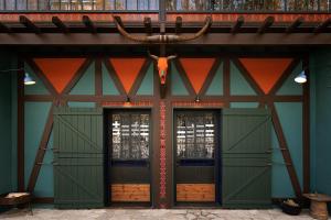 a building with two green doors with a bull head on it at Vasilikia Mountain Farm & Retreat in Pavliani