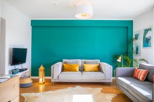 a living room with a couch and a blue wall at Toi et Moi Apartments-Guests speek for us! in Ponta Delgada