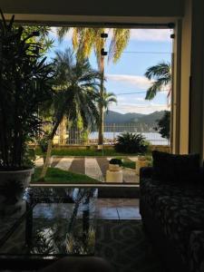 a living room with a view of a palm tree at Apartamento Messi Assú Praia dos Milionários in São Vicente