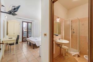 a bathroom with a sink, toilet and shower at Hotel Villa Piras in Alghero