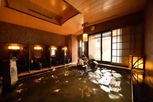 uma grande piscina de água com pessoas nela em Dormy Inn Tomakomai em Tomakomai