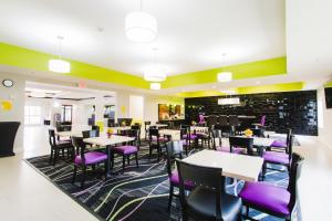 a dining room with tables and purple chairs at Palacio Royale Inn Signature Katy in Katy