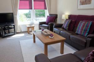 a living room with a couch and a coffee table at Sanaigmore Cottage in Port Charlotte