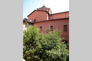 a red brick building with a dome on top of it at Casa di Spagna in Bologna