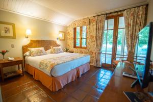 a hotel room with a bed and a large window at Viña La Playa Hotel & Winery By Sutil Wines in Santa Cruz