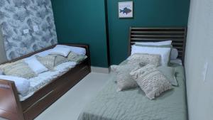 2 camas individuais num quarto com paredes verdes em Edifício Panoramique 180 Graus, Cobertura no Guarujá