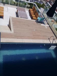 uma piscina com uma cadeira e uma piscina em Edifício Panoramique 180 Graus, Cobertura no Guarujá