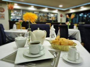 a table with a cup of coffee and a basket of bread at San Francisco Cusco Hotel in Cusco
