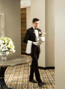 a man in a tuxedo holding a cup of coffee at Marquis SkySuites in Mexico City