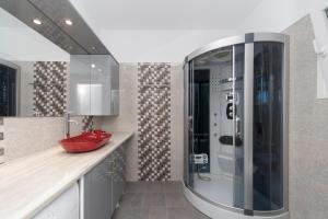 a bathroom with a shower with a red sink at Ormos Naoussa's suite in Naousa +10 photos