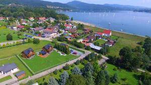 an aerial view of a house with a lake at Cztery Pory Roku - kominek, sauna, jacuzzi in Zarzecze
