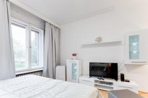 プラハにあるExclusive Riverside Apartment in the Heart of Pragueの白いベッドルーム(ベッド1台、テレビ付)