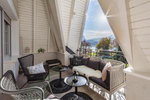 een balkon met een bank, tafels en stoelen bij Apartment Vila Pavlovski in Bled