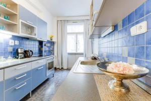 プラハにあるExclusive Riverside Apartment in the Heart of Pragueの青いタイル張りのキッチン(床にボウル付)
