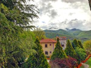 a house in a garden with trees and mountains at Hotel Nemesis in Stavroupoli