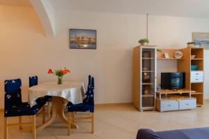 a living room with a table and chairs and a television at Apartmani Juraj in Zavalatica