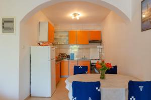 Il comprend une cuisine équipée d'une table et d'un réfrigérateur. dans l'établissement Apartmani Juraj, à Zavalatica