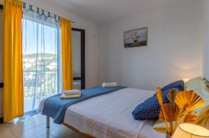 a bedroom with a bed and a large window at Apartmani Juraj in Zavalatica