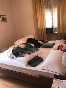 Dos camas en una habitación con ropa. en Albergo GARNI' AURORA, en Tret