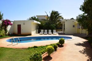 a swimming pool in front of a house at Villa Du Soleil Ngaparou in Ngaparou