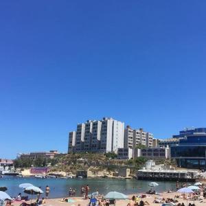 a group of people on a beach with umbrellas at Pembroke Suites in Pembroke