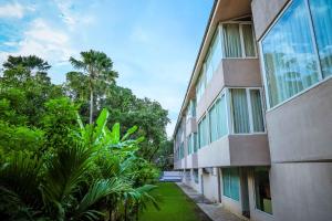 an external view of a building with green plants and trees at Hotel Regent Laguna in Anjuna