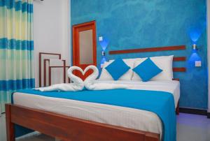 a bedroom with a bed with two hearts on it at Blue Berry Villa in Hikkaduwa