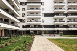 an external view of an apartment building with a courtyard at M&R Apartament Airport&Business Premium Komputerowa - underground garage - free WiFi - Netflix - self check-in - 5 min from Chopin Airport in Warsaw