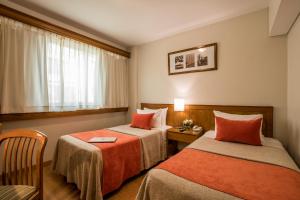 a hotel room with two beds and a window at Hotel Solans Carlton in Buenos Aires