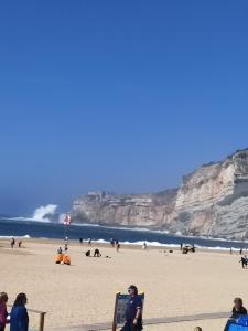 un gruppo di persone sedute sulla spiaggia di Casa da Leninha a Nazaré