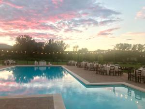a pool with tables and chairs and a sunset at Il Pianaccio in Spoleto