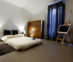 sypialnia z łóżkiem i telewizorem w obiekcie Zenthe Small Luxury B&B w mieście Brindisi