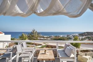 a patio with chairs and a table and a view of the ocean at Althea Boutique Hotel - Adults Only in Amoopi