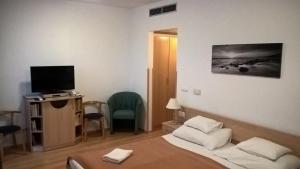 a hotel room with a bed and a television at Lilla Wellnessapartman in Zalakaros
