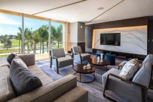 a living room with couches and a flat screen tv at Legacy Hotel at IMG Academy in Bradenton